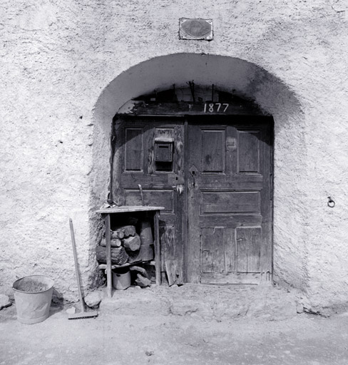 Draille, parcelle 213. Porte d'entrée à panneaux compartimentés datée 1877.