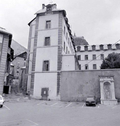 Vue de la fontaine adossée au mur de l'ancien hôpital. ; Ancien hôpital militaire et extrémité méridioale de la rue de Roche prise de la place Médecin Général Blanchard.