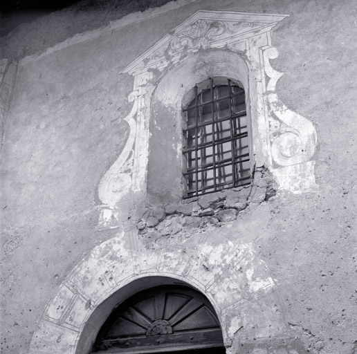 Façade sud. Deuxième travée. Fenêtre et arc de la porte. Décor de plâtre architecturé.