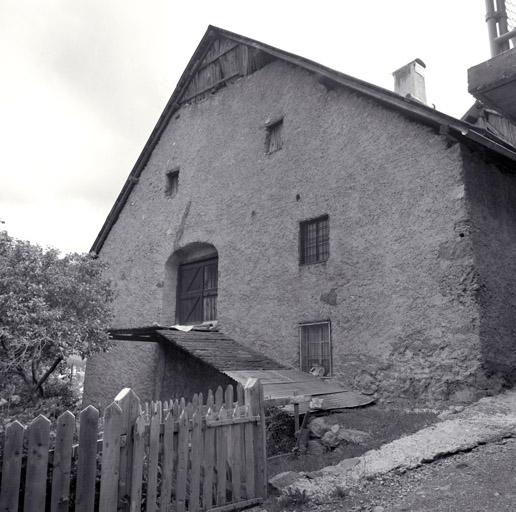 Ferme 92. Façade nord avec entrée de la grange sur rampe de bois en porte-à-faux. ; Le Serre. Parcelle 92. Façade nord avec entrée de la grange sur rampe de bois en porte-à-faux.