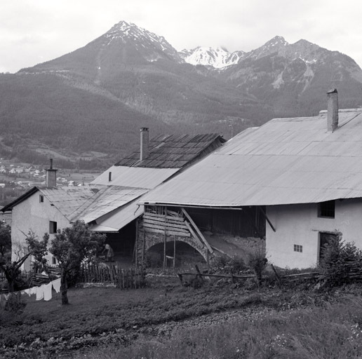 Côté nord. Entrée de grange. La rampe, parallèle à la façade, est portée par un arc et abritée par le débordement de la toiture. ; Ferme 442. Côté nord. Entrée de grange. La rampe, parallèle à la façade, est portée par un arc et abritée par le débordement de la toiture.