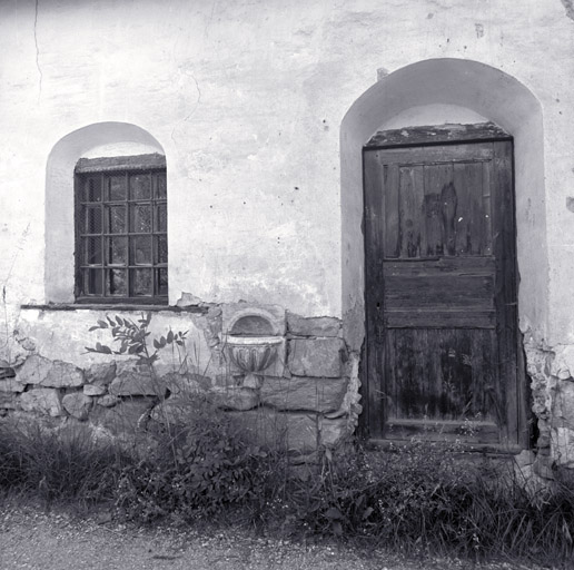 Façade antérieure. Fenêtre et porte ébrasées. Bénitier de marbre.