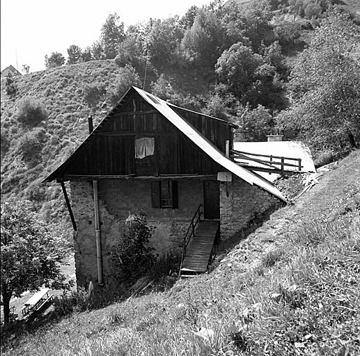Les Estaris. Le bardage de planches est construit en encorbellement au-dessus du mur-pignon.