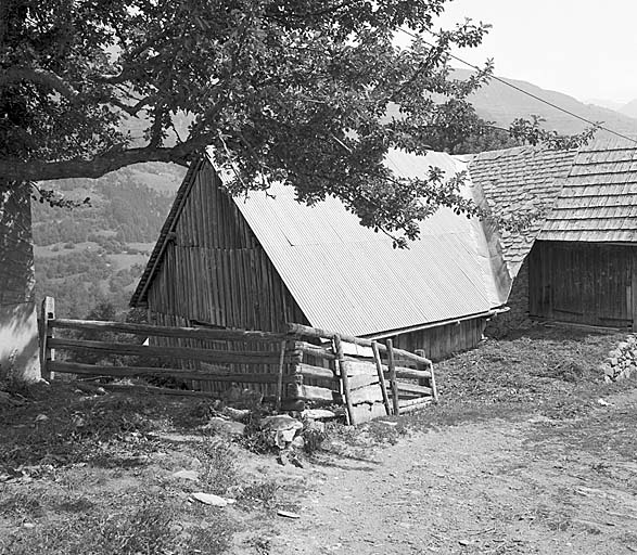 Vue prise du sud-ouest. Le toit de la maison initiale est couvert d'ardoises. Dans le même prolongement on a construit un appentis en planches couvert de bardeaux. Le corps de bâtiment perpendiculaire, couvert de tôle, qui abrite une bergerie et une grange, est postérieur à la maison.