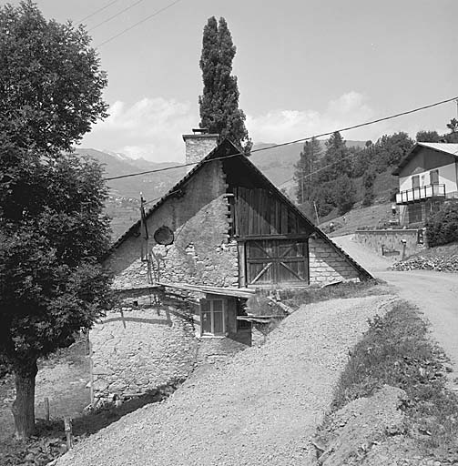 Les Audiberts, parcelle 553, pignon sud. La partie droite de la grange est ventilée par un bardage de planches, la partie gauche par un oculus masqué par un fond de panier pour éviter que la neige ne pénètre dans la grange.