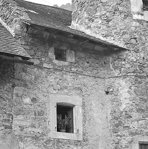 Fenêtre chanfreinée de la grange au niveau supérieur et fenêtre de la chambre (transformée en 1804 ?). L'avant-toit est fermé par une corniche en pierre.