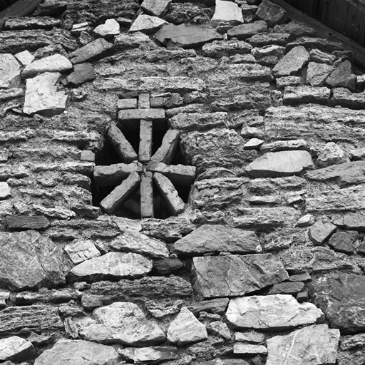 Le Lauzet. Parcelle 704. Oculus fermé par des briques. Noter les moellons de tuf de la maçonnerie autour.