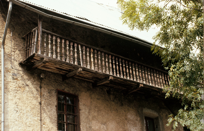 Le Casset. Parcelle 1221. Façade sud-est, deuxième étage. Grand balcon de grange en bois à balustres tournés.