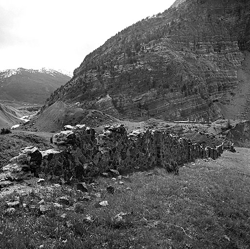 Mur défensif. Aile droite, face intérieure vue de la route D 89. Au-dessus, à l'arrière plan, la position du replat des Rebans sur la pente du Lasseron.