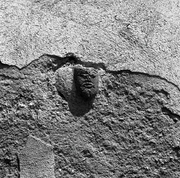 Remploi sculpté représentant une tête humaine.