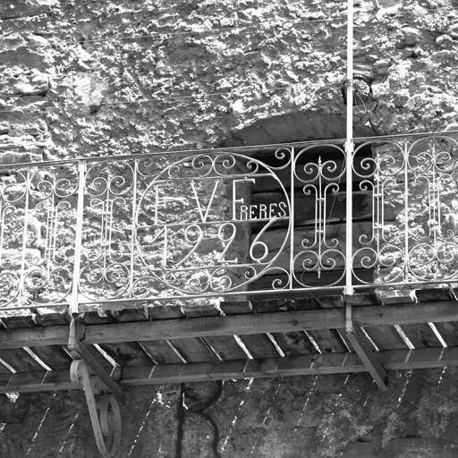 Fontchristianne. Parcelle 648. Façade ouest. Balcon en fer forgé. Le médaillon central porte l'inscription F V Frères / 1926. Au-dessous, trois ancres figurant les lettres R, S et C.