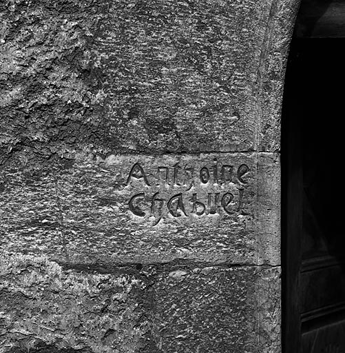 Façade sud. La porte gauche. Inscription gravée sur le piédroit gauche.