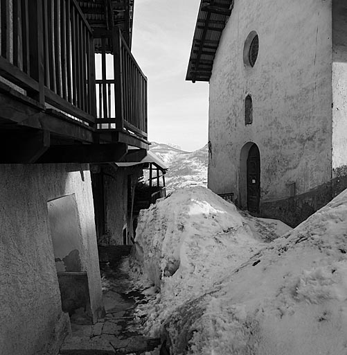 Puy-Aillaud. Rue. Noter la façon dont les balcons protègent les abords immédiats de la maison. Vue prise en mars 1982 devant la chapelle Sainte-Agathe.