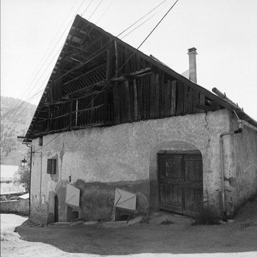 Le Villard-Laté. Parcelle 1073. Pignon nord avec entrée de grange de plain-pied. Noter la protection des fenêtres en-dessous du niveau du sol.