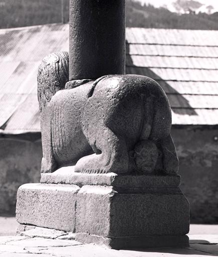 Lion portant la colonne centrale du porche, vu de trois-quarts dos.