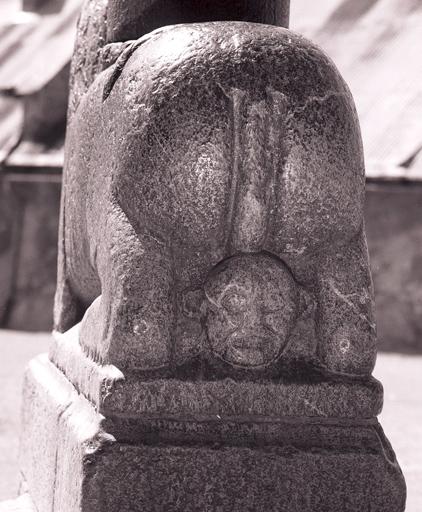 Lion portant la colonne centrale du porche, vu de dos.