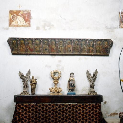 Vue d'ensemble de la prédelle et objets exposés contre le mur nord de la chapelle latérale gauche.