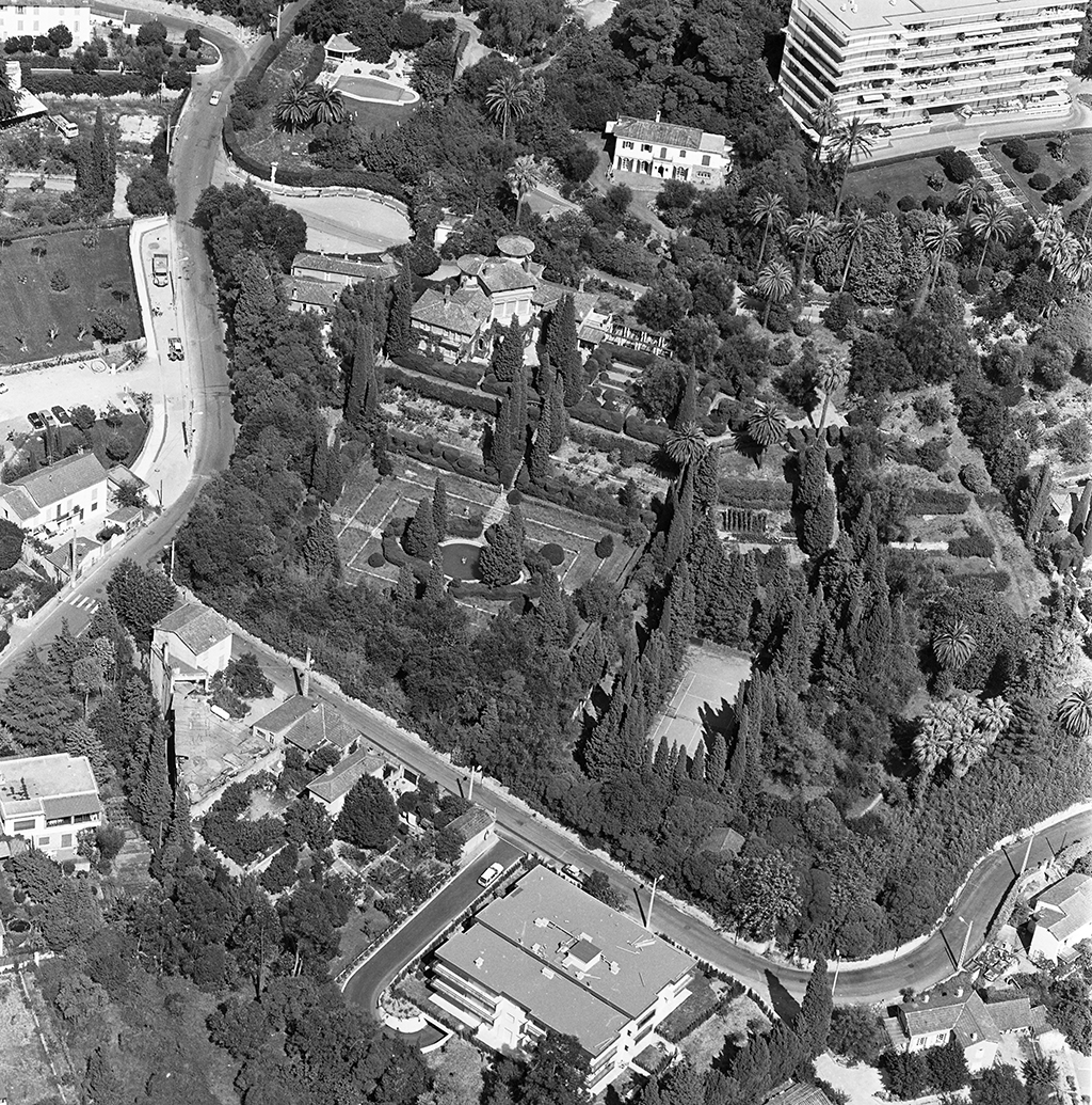 Vue aérienne d'ensemble prise du sud-ouest. ; Vue aérienne prise du sud. La maison est en haut de l'image, à gauche de l'immeuble.