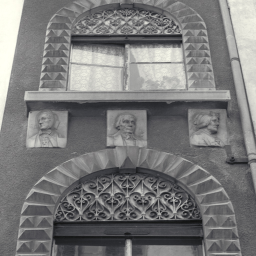 Façade antérieure est. Troisième niveau. Reliefs d'applique. Effigies.