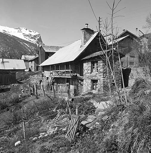 Parcelle 299. Vue de volume prise du sud-est. Au premier plan la chambre qui a été surélevée. La façade de la maison a conservé son aspect traditionnel et sa galerie de séchage.