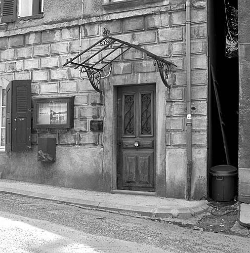 Maison rue de Chaillol (parcelle 912). Faux bossage façonné dans l'enduit et auvent en ferronnerie autrefois vitré.