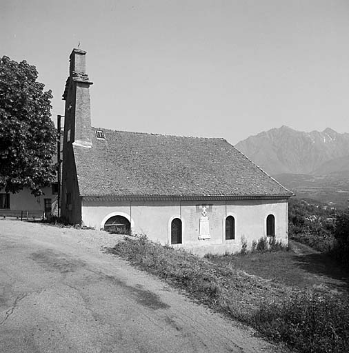 Vue prise du sud. Au centre du mur, le monument aux morts. Les baies sont entourées d'un faux appareil enduit.