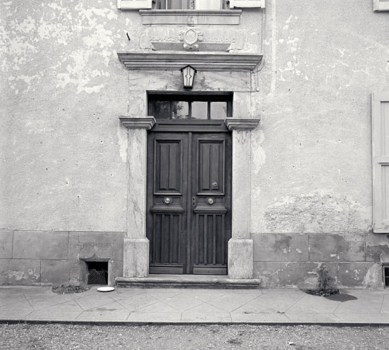 La porte d'entrée du corps de logis. En bas à gauche fenêtre en accolade éclairant les caves.