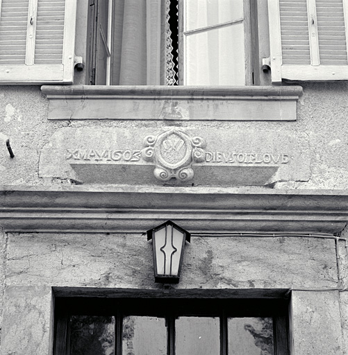 Le linteau de l'ancienne porte en remploi au-dessus de la porte fin XIXe.