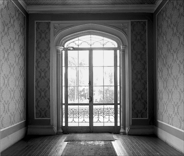 Une chambre. Embrasure néo-gothique de la porte-fenêtre.