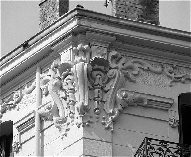 Angle de deux façades. 4e niveau. Couronnement sculpté.