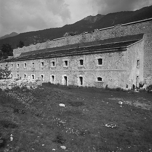 Bâtiment A. Façade principale. A l'arrière plan, sur la crête, à gauche, sommet de Château Jouan (Janus) et, à droite, fort de l'Infernet.