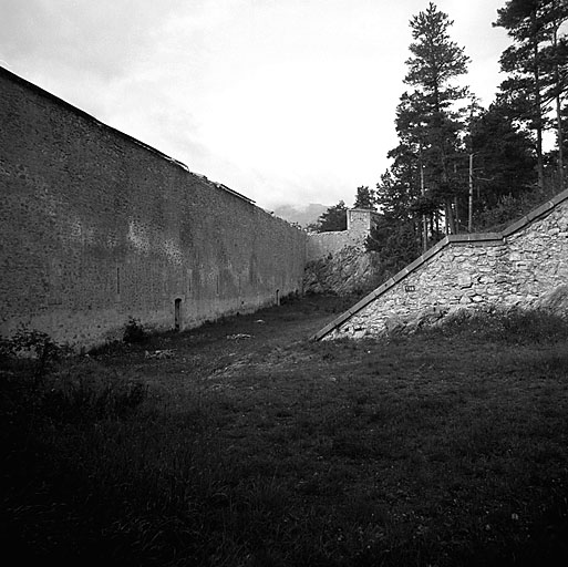 Intérieur du fort vu du bastion 2. Front sud-est. A gauche, courtine du parados/retranchement intérieur, crénelé, avec portes de sortie de la caserne. A droite, rempart de la courtine et terre-plein intérieur du bastion 2.