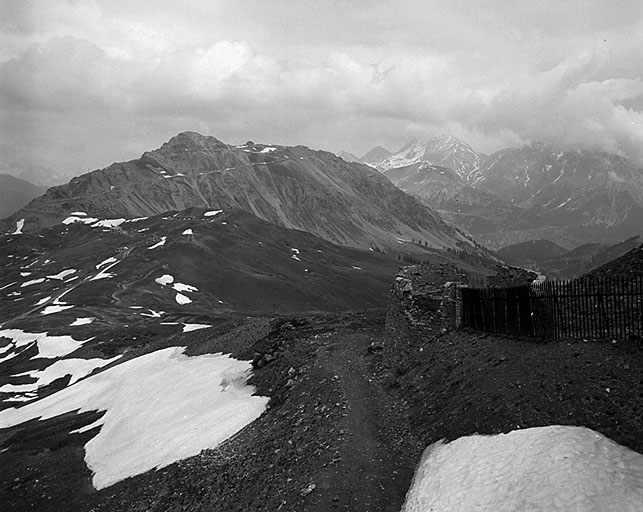 Vue d'ensemble prise de l'ouvrage C vers le nord. Au premier plan le tambour de gauche et la grille défensive de l'ouvrage C. Au deuxième plan, le mamelon de l'ouvrage A, avec, à contrepente, l'abri de combat et le chalet de montagne du 159e RIA. Au troisième plan, la crête de Château Jouan et l'ouvrage du Janus.