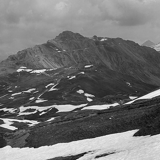 Crête du Gondran. Vue d'enfilade sud-nord prise depuis l'arrière de l'ouvrage C. En bas, à droite, la batterie et l'abri magasin n° 2. Au-delà du col, en remontant en enfilade, la tranchée-abri, l'ouvrage B et, couronnant le mamelon l'ouvrage A, avec, à contrepente, l'abri de combat A et le chalet de montagne du 159e RIA. Au fond, le sommet de Château Jouan, la route militaire et l'ouvrage du Janus.