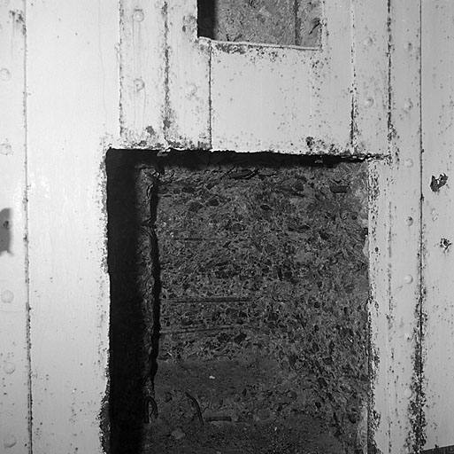 Bloc 4. Vue intérieure de la chambre de tir. Dans le mur de fond, une niche creusée après coup, pour permettre le débattement d'une arme mixte, dont l'installation était projetée en remplacement du J.M. Au-dessus, le logement réservé pour le birail porteur.
