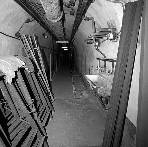 Chambre de troupe. A gauche, des éléments de literie démontés, à droite, un lavabo.