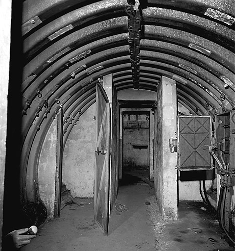 Vue intérieure. Local 5. A droite : une boîte de coupure type 2, de part et d'autre du passage les cabines téléphoniques 3 et 4, au fond, le local 1 : la cuisine.