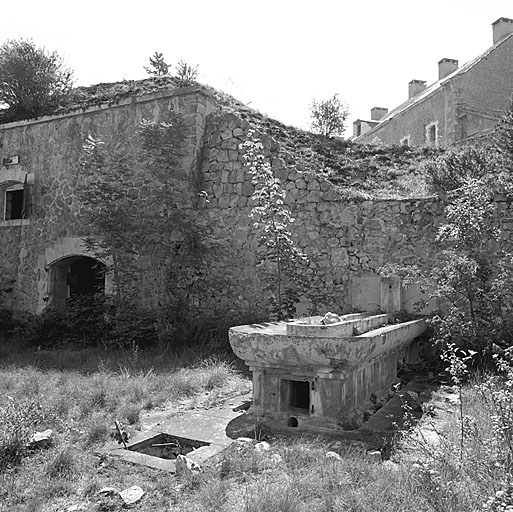 Cour du bâtiment O. A gauche, la façade du bâtiment X (magasin à poudre mi-caverne) et le lavoir.