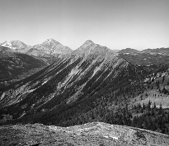 Vue prise du cavalier supérieur vers le nord-est. Au fond, à gauche, Cime de Pece, montagne du Chaberton dominant le village de Montgenèvre. Au centre, sommet de Château Jouan masquant le fort du Janus. A droite, partie gauche du plateau du Gondran et ouvrages A.
