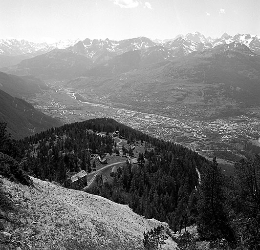 Baraquements de la Seyte. Vue d'ensemble du site pris des derniers lacets de la route du fort de l'Infernet. A l'arrière gauche, infirmerie-hôpital. Au fond et en contrebas, Briançon et la vallée de la Durance.