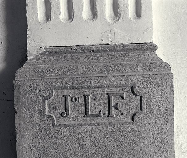 Inscription sculptée en réserve sur la base du pilastre droit de la nef.