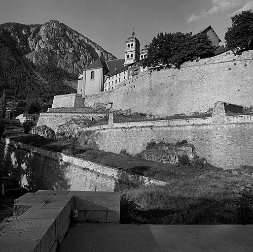 Enceinte de ville. Front ouest. Vue sud-nord prise depuis l'avant porte d'Embrun. Au premier plan, la contregarde générale. Au deuxième, la fausse braie, enfin le corps de place et la ville. A l'arrière plan, en haut et à gauche, position de la Croix de Toulouse.