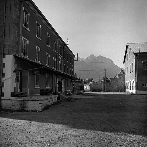Vue prise dans la cour centrale vers le sud. A gauche le bâtiment 007. Au fond, porte de l'ancien embranchement ferré. A droite, extrémité est du bâtiment 010.