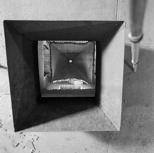 Bâtiment 010. Vue intérieure d'un silo prise depuis l'orifice supérieur. Remarquer les essais de démolition de la paroi en béton armé.