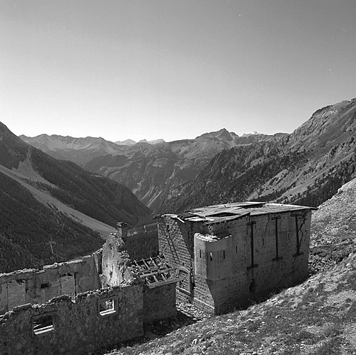 Poste défensif et baraque f vus du nord. Derrière, le vallon des Acles, la vallée de la Clarée et la crête de Peyrolle avec le pic de la Roche Gauthier.