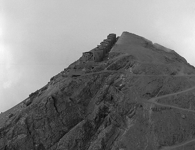 Vue aérienne prise du nord-nord-est. A droite, l'arrivée de la route stratégique et le casernement 308. A gauche, le bâtiment de la batterie et les tours-supports des 8 tourelles de 149 avec, saillant à gauche, le bâtiment de la recette supérieure du téléphérique.