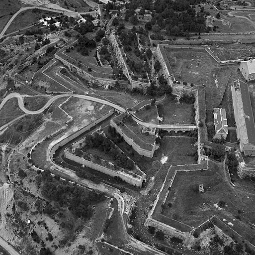 Vue aérienne prise du nord-est dans l'alignement de la courtine du front 1-3. Au centre et à droite, les bâtiments A (porte Royale) et B (caserne).