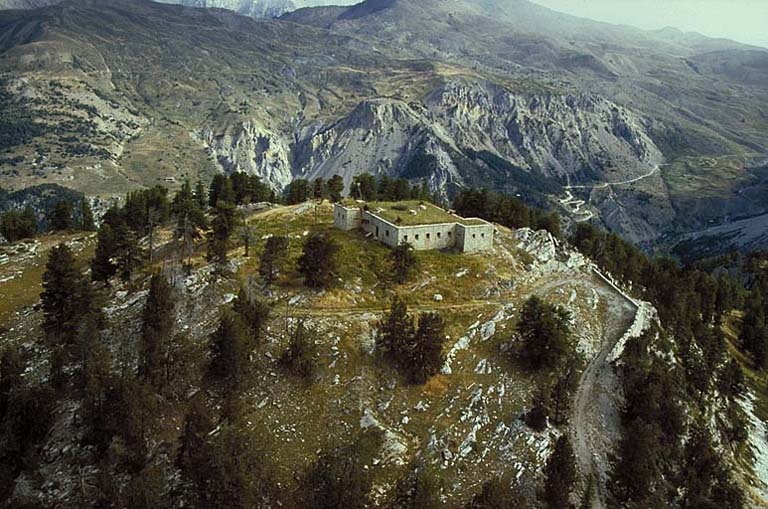 Vue aérienne du blockhaus prise du sud-ouest. Au deuxième plan, le replat du Gondran et Chenaillet, le col Gimon. A l'arrière plan, à gauche, dans la brume, le Chaberton.