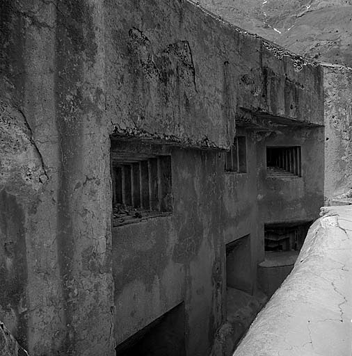 Bloc 5. Vue oblique rapprochée de la façade sud-est. De gauche à droite : en haut : deux créneaux frontaux de JM - créneau de FM ; en bas : deux créneaux frontaux de mortier de 81 mm et mortier de 50 mm.