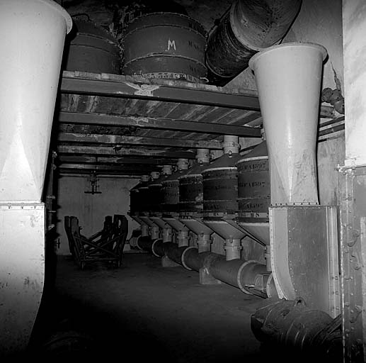 Salle de neutralisation. Au premier plan, bouches de soufflage verticales et ventilateur. Au-dessus, filtres de rechange.